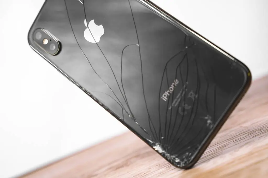 iPhone XR avec vitre brisée posé sur une table — fissures visibles illustrant la nécessité d’un remplacement d’écran.