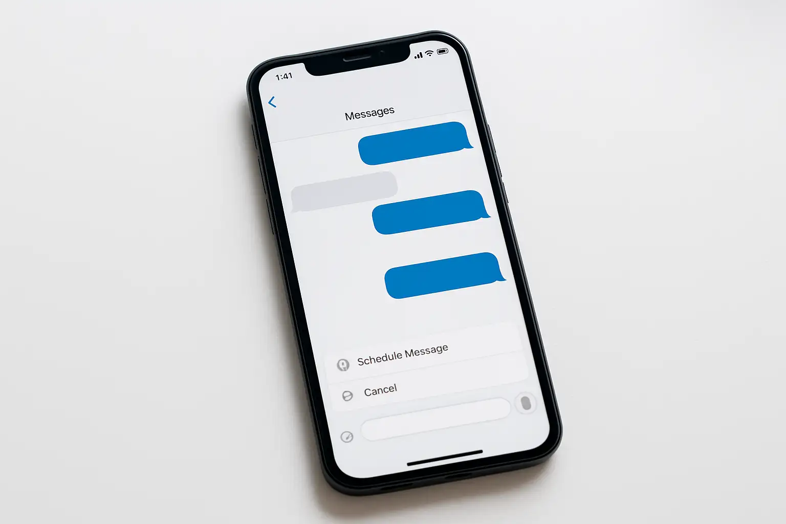 iPhone affichant l’app Messages avec une conversation iMessage et l’option d’envoi programmé